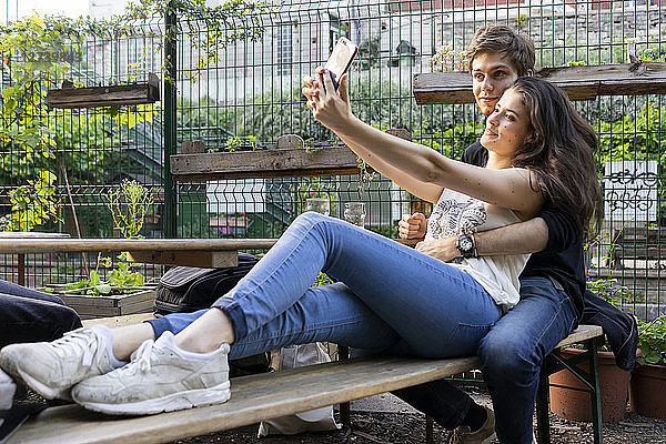 Young couple taking a selfie at an outdoor bar