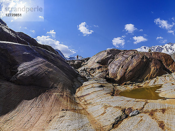 Italy  Lombardy  Cevedale Vioz mountain crest  hiker at rocks shaped from Forni glacier