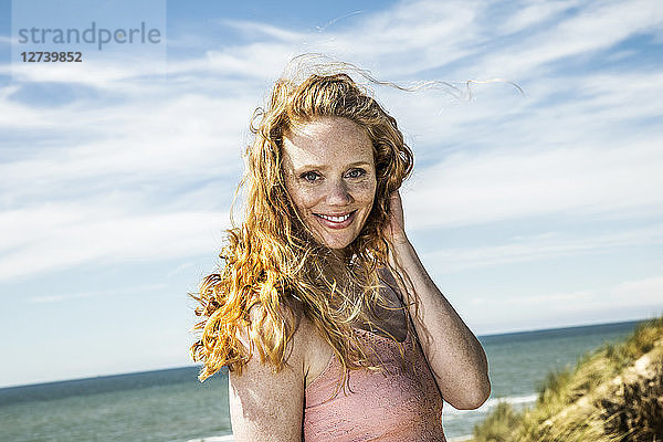 Netherlands  Zandvoort  portrait of smiling woman at the coast