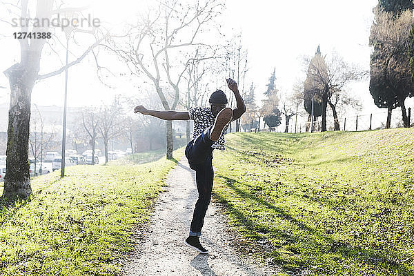 Young man exercising to kickbox in park