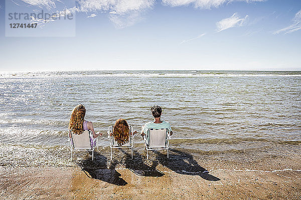 Netherlands  Zandvoort  family sitting on chairs in the sea