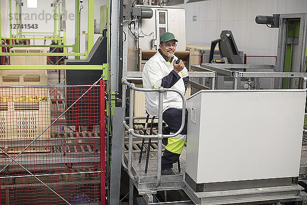 Worker sitting at apple packing machine