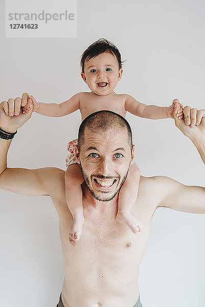 Portrait of father carrying little daughter on shoulders