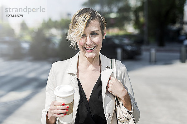 Portrait of smiling businesswoman with Coffee to go