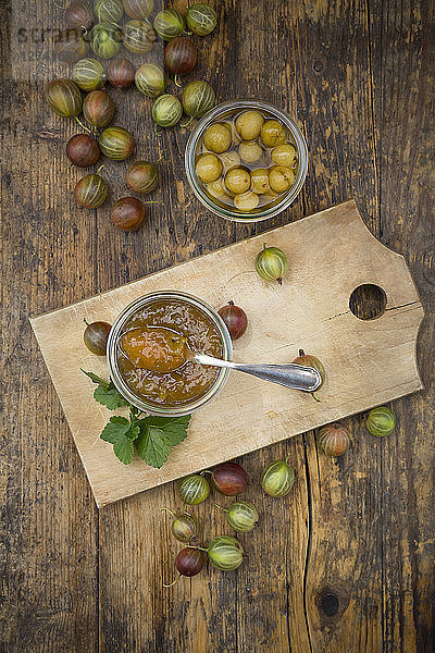 Jar of gooseberry jam  gooseberries and glass of preseved gooseberries on wood
