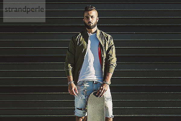 Portrait of young man with skateboard