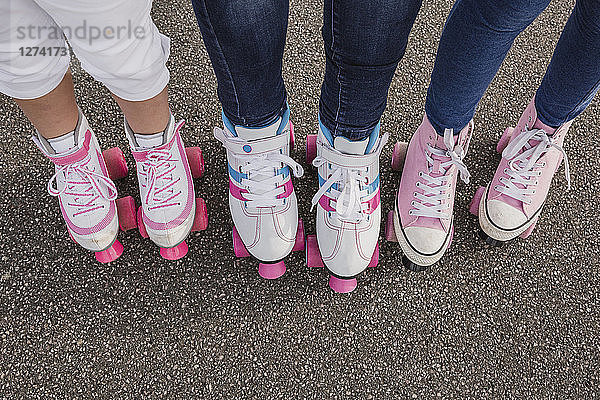 Mother and her two daughters on roller skates  partial view