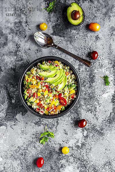 Bowl of bulgur salad with bell pepper  tomatoes  avocado  spring onion and parsley