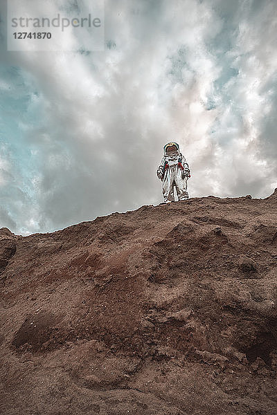 Spaceman standing on slope of nameless planet