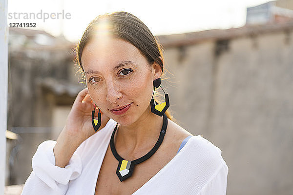 Portrait of young woman wearing modern necklace and earrings