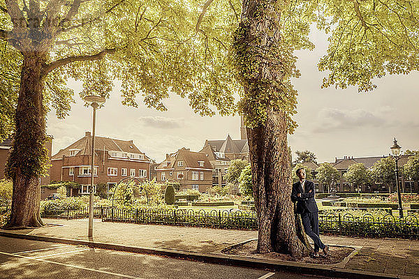 Netherlands  Venlo  businessman leaning against a tree
