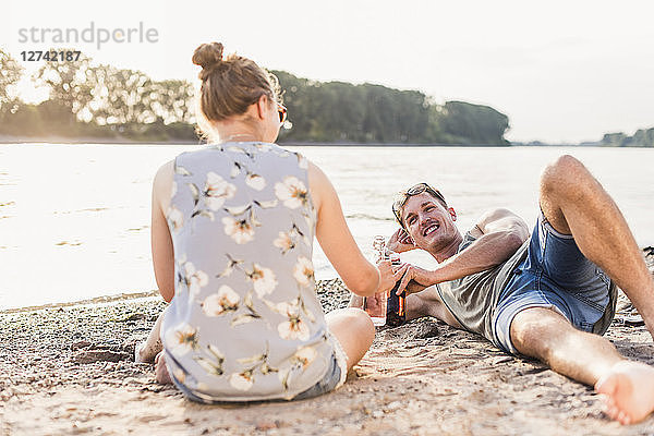 Young couple relaxing at the riverbank