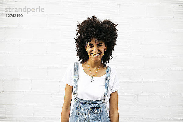 Portrait of laughing woman in front of white wall