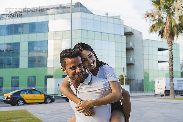 Happy couple in the city  man carrying his girlfriend piggyback