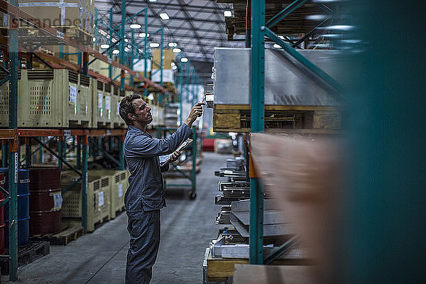 Worker in factory warehouse taking stock