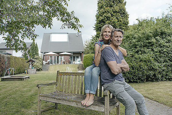 Smiling mature couple in garden of their home