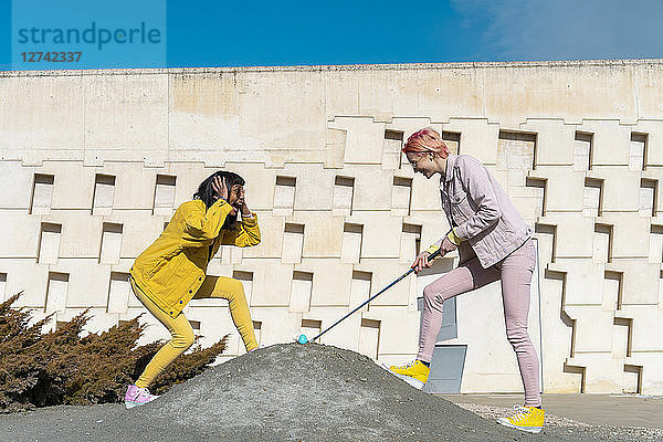 Two alternative friends golfing