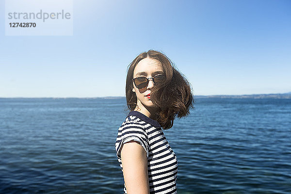 Italy  Lake Garda  portrait of young woman with brown hair wearing sunglasses