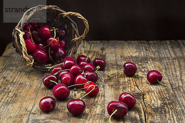 Wickerbasket of cherries on wood