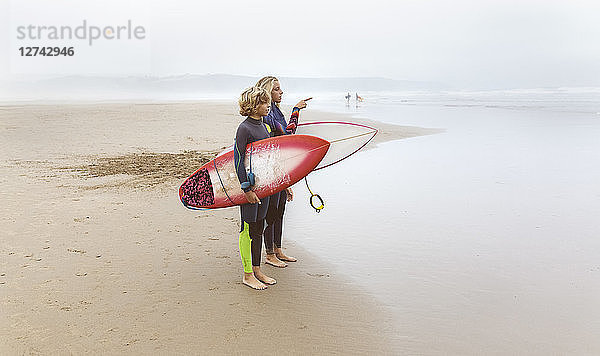 Spain  Aviles  two young surfers on the beach