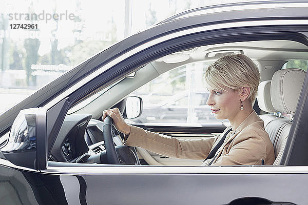 At the car dealer  Woman sitting in new car