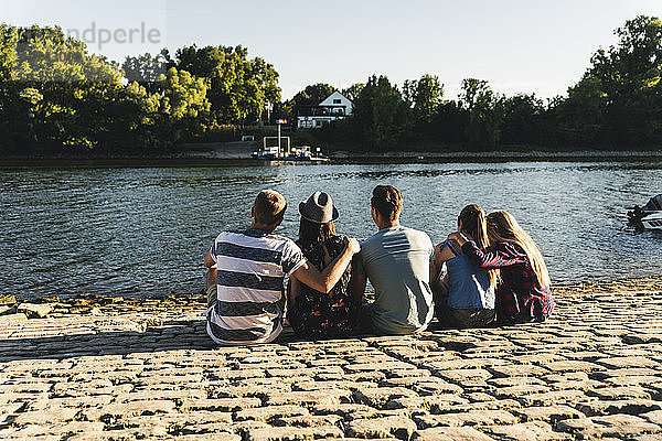 Group of friends sitting at the water looking out