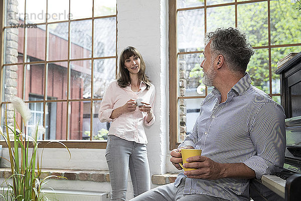 Mature couple at home taking a break  talking and drinking coffee