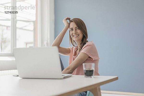 Woman at home sitting at desk with laptop