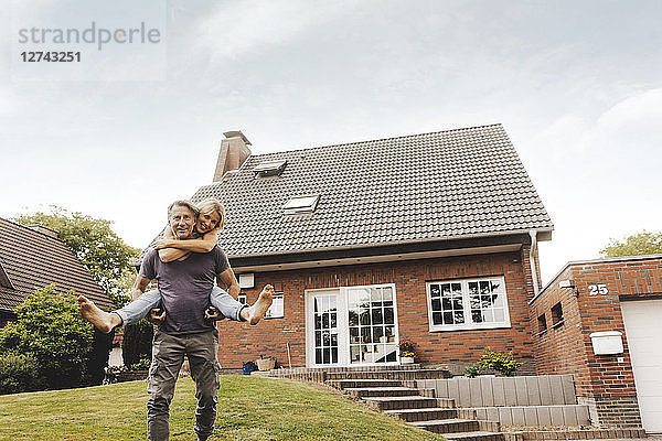 Happy mature couple in garden of their home