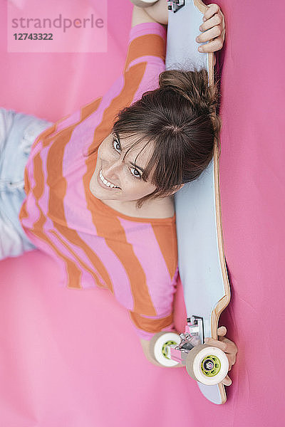 Woman holding skateboard  looking up