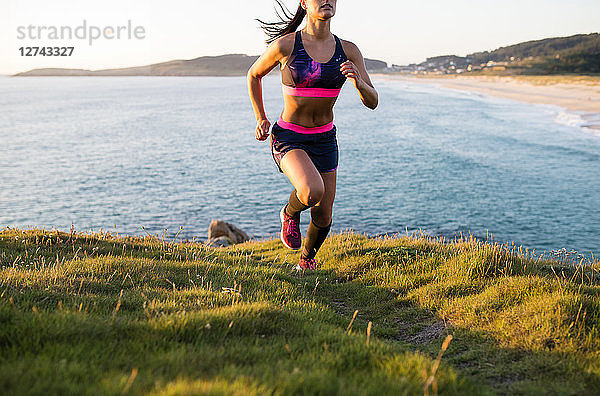 Woman running in a coastal landscape