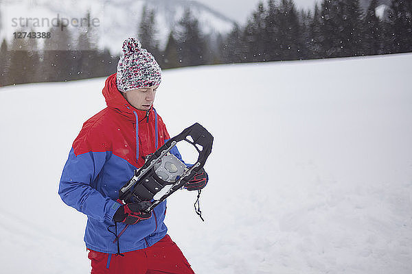 Man putting on snow shoes