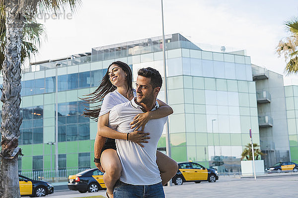 Happy couple in the city  man carrying his girlfriend piggyback