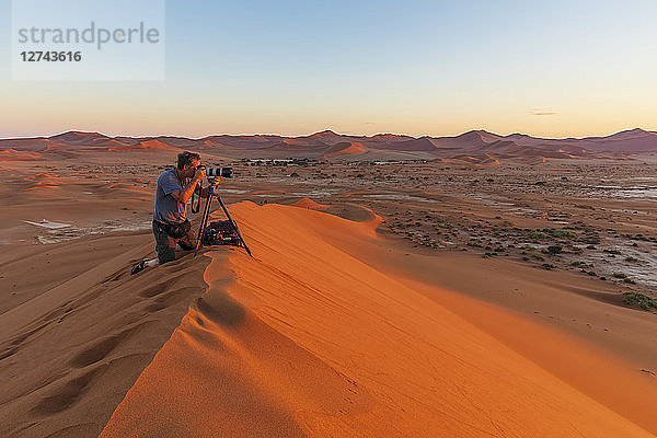 Africa  Namibia  Namib desert  Naukluft National Park  photograper on sand dune at sunrise