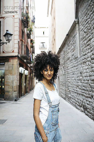 Spain  Barcelona  portrait of smiling woman with curly hair