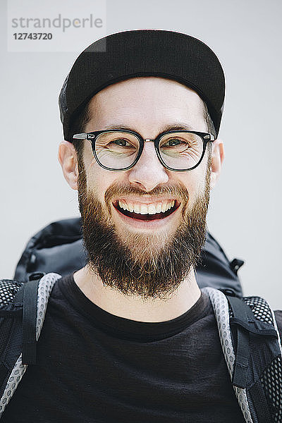 Portrait of laughing man with backpack dressed in black
