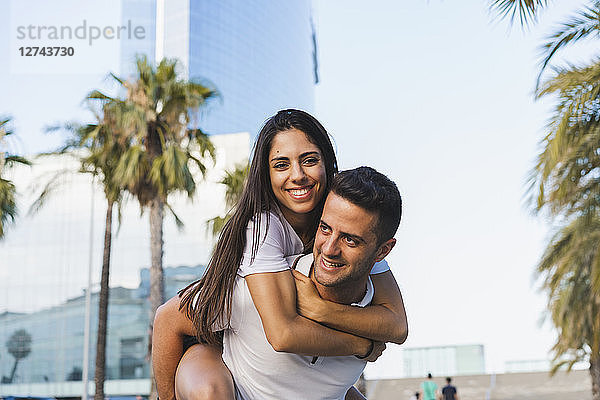 Happy couple in the city  man carrying his girlfriend piggyback