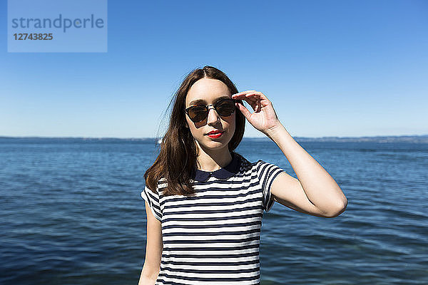 Italy  Lake Garda  portrait of young woman wearing sunglasses