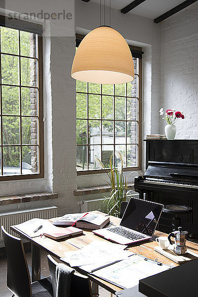 Home office with piano in background at comfortable loft apartment
