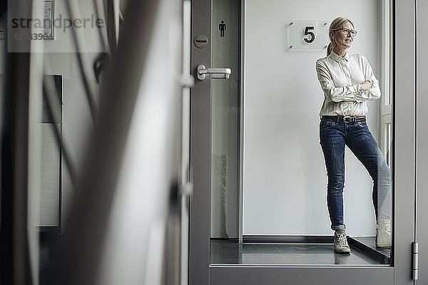 Businesswoman standing on the corridor looking out of window