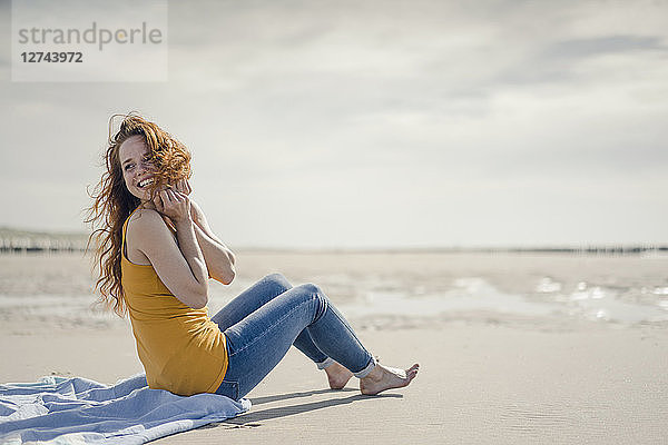 Woman sitting on the beach  laughing