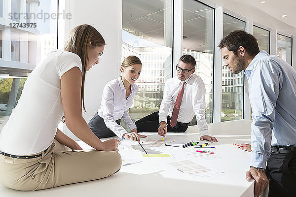 Team of four business people having a meeting at conference table