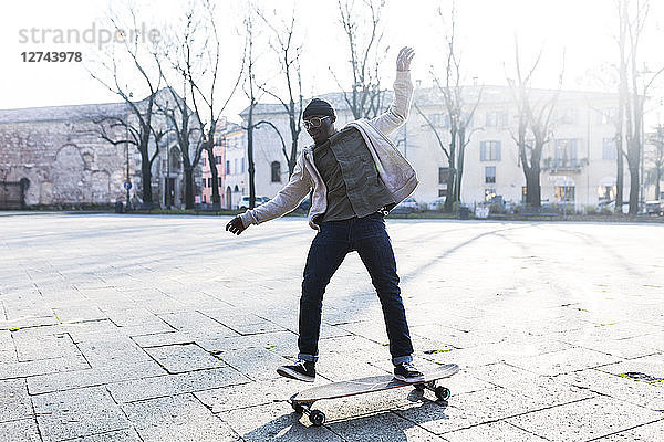 Young man skateboarding on an urban squarre