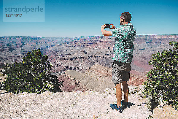 USA  Arizona  Grand Canyon National Park  Grand Canyon  man taking photos with smartphone