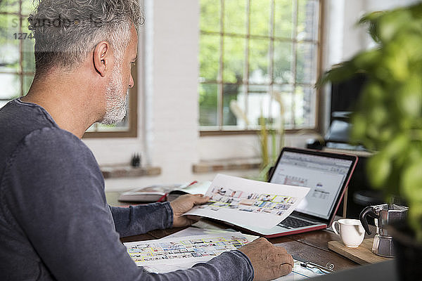 Mature man working in his home office at a loft apartment