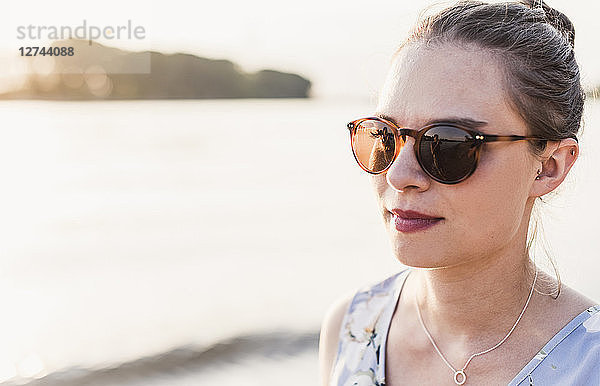 Young woman wearing sunglasses at the riverbank