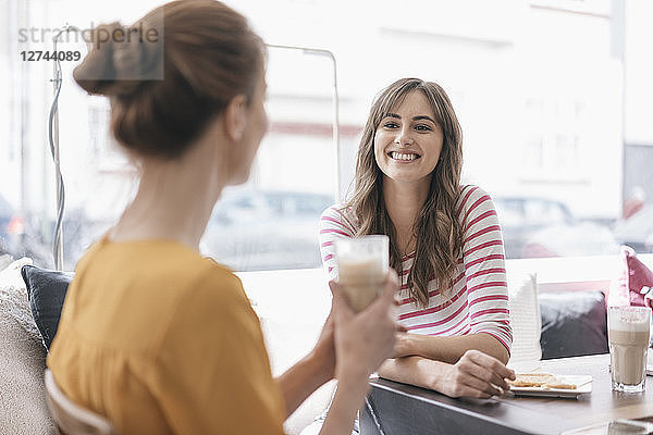 Two girlfriends meeting in a coffee shop  talking