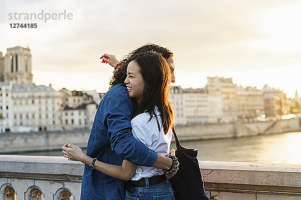 France  Paris  happy young couple hugging at river Seine at sunset