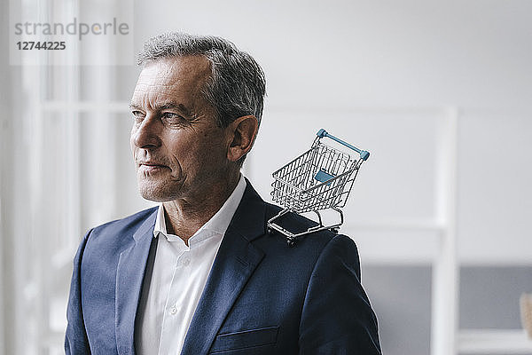 Portrait of manager with mini shopping cart