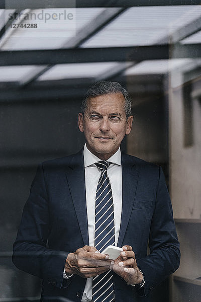 Portrait of mature businessman with cell phone